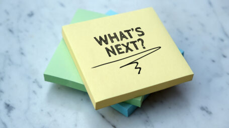 Yellow sticky note pad with what's next on it.