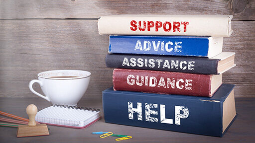 Support concept. Stack of books on wooden desk. a stack of books that say 