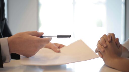 Two people talking, hands only looking at a paper