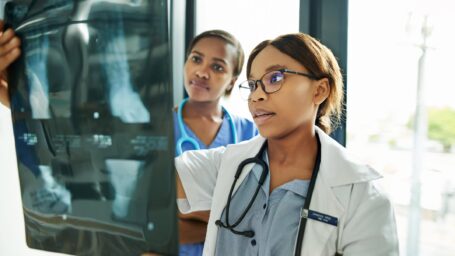 Shot of two medical practitioners analysing x-rays in a hospital